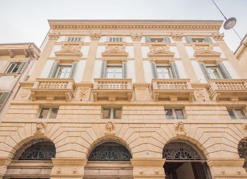 Palazzo Monga Boutique Guesthouse in Verona, ornate historic facade with tall arched windows