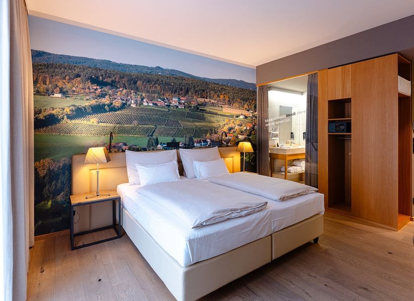Hotel Stainzerhof in Stainz guest room with double bed, wall mural, and open bathroom doorway