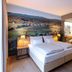 Hotel Stainzerhof in Stainz guest room with double bed, wall mural, and open bathroom doorway