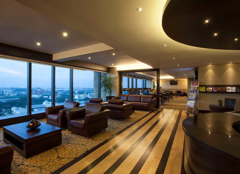 The Oterra, Bengaluru lounge with floor-to-ceiling windows and city views, plus seating area