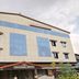 Hilltown Hotel in Madikeri exterior with beige facade and blue window panels