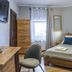Royal Gdansk guest room with wooden bed, wardrobe, desk, chair, and window in Gdansk