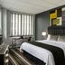 Broadway Plaza Hotel New York guest room with king bed, striped rug, desk and city-window blinds