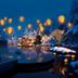 Aomoriya by Hoshino Resorts in Misawa, lantern-lit outdoor pool or bath amid snowy trees at dusk