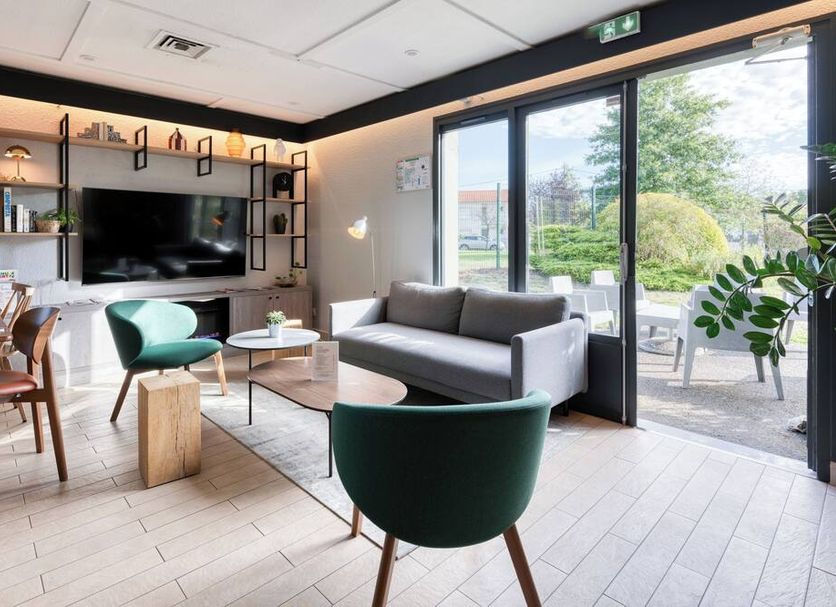 Campanile Nature - Bordeaux Sud Pessac lounge with sofa, TV wall, and patio doors in Pessac