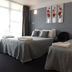 Raceway Motel Whanganui room with two double beds, wall art, and window light