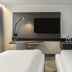 Novotel Düsseldorf Airport room with twin beds, wall-mounted TV, desk, and chair in Düsseldorf