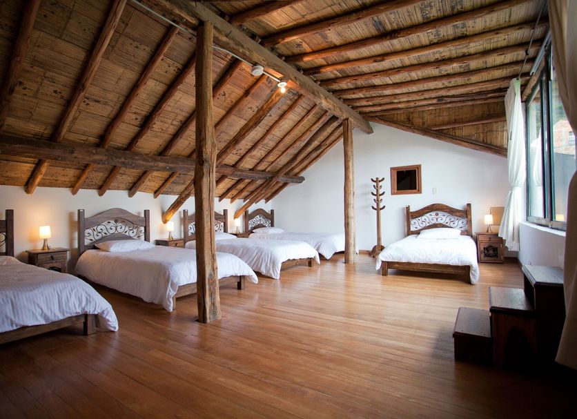 Arche Noah Boutique Hostel Bogotá attic dorm room with four beds and wooden ceiling