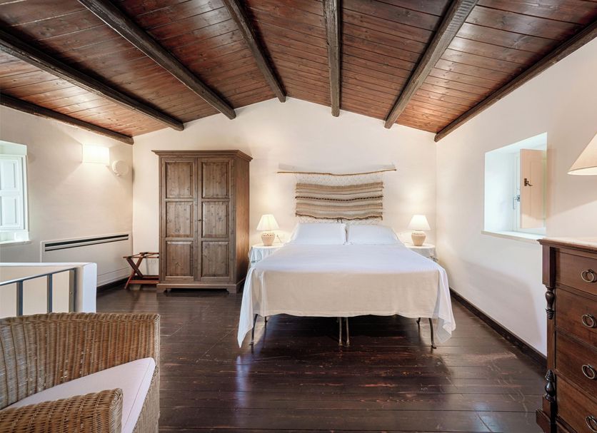Masseria Degli Ulivi in Noto: bedroom with wooden ceiling, bed, armoire and dark wood floor
