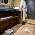 Hôtel Du Centenaire bathroom with robe, towels, slippers and marble shower in Les Eyzies-de-Tayac-Sireuil