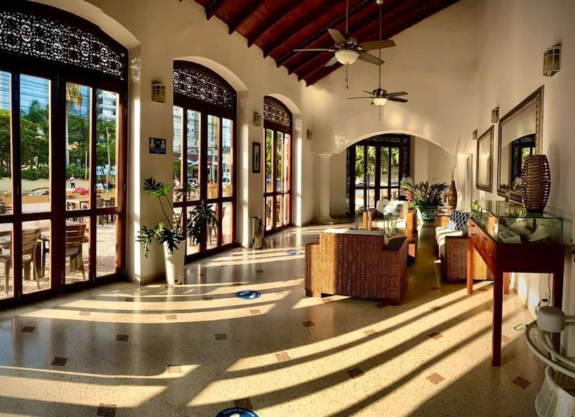 San Martin Cartagena lobby with arched windows, wicker seating and sunlight on tiled floor in Cartagena