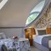 Schloss Hotel Dresden Pillnitz guest room with canopy bed and round table by arched window in Dresden