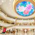 Dongguan Huaxi International Hotel lobby with a large floral ceiling mural and gold-accented balconies in Dongguan