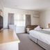 Hospitality Carnarvon guest room with king bed, sofa, TV, and window in Carnarvon