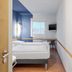 B&b Hotel Erlangen-tennenlohe guest room with twin beds, blue accent wall, window and wall-mounted TV in Erlangen