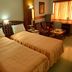 Hotel City Tower Coimbatore guest room with two single beds, seating area, and window view