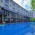 Grand Santhi Hotel in Denpasar with a large outdoor swimming pool beside the building