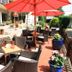 Outdoor terrace at Akzent Hotel Berlin in Bad Bevensen with red umbrellas, wicker seating and potted flowers