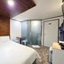 Hotel Atti Incheon guest room with bed, wood accent wall, desk, and frosted glass shower door