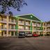 HomeTowne Studios by Red Roof Austin exterior at dusk with parking lot and three-story motel building