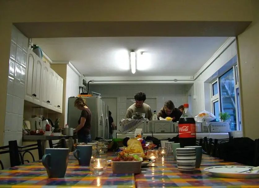 Lahinch Hostel in Lahinch dining room with a shared table, guests, and kitchen area