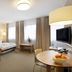 Hotel am Jakobsmarkt Nuremberg guest room with bed, table, TV, and large windows