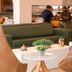 Strassen Hotel, Goiânia lobby lounge with green sofas, white tables and guests seated in the background