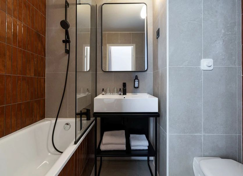 Grand Hôtel De La Seine Rouen bathroom with bathtub, shower, sink, mirror and tiled walls
