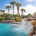 Legacy Vacation Resorts - Palm Coast pool with waterfall, palm trees and lounge chairs