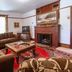 Margaretville Mountain Inn B&B living room with fireplace, leather sofas, TV, and patterned rugs in Margaretville