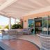 Park Hotel Asinara in Stintino: covered terrace with seating and sliding glass entrance doors