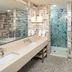 Hilton Garden Inn Sioux Falls Downtown bathroom with double vanity, glass shower, and soaking tub