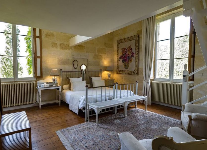 Petit Garros guest room in Saint-Michel-de-Fronsac with twin beds, large windows, and a sitting area