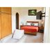 La Joya Del Lago in Ajijic: simple guest room with bed, armchair, wall-mounted TV and wooden wardrobe