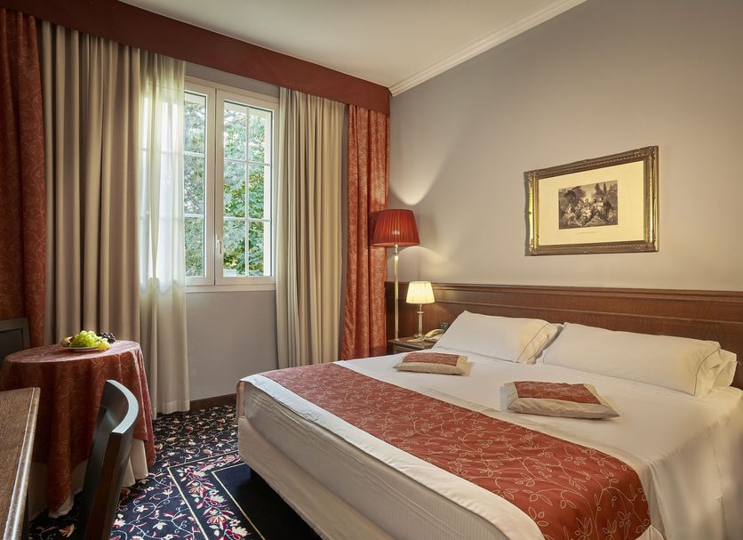 Meditur Hotel Bologna room with double bed, window, bedside lamps and table in San Lazzaro di Savena