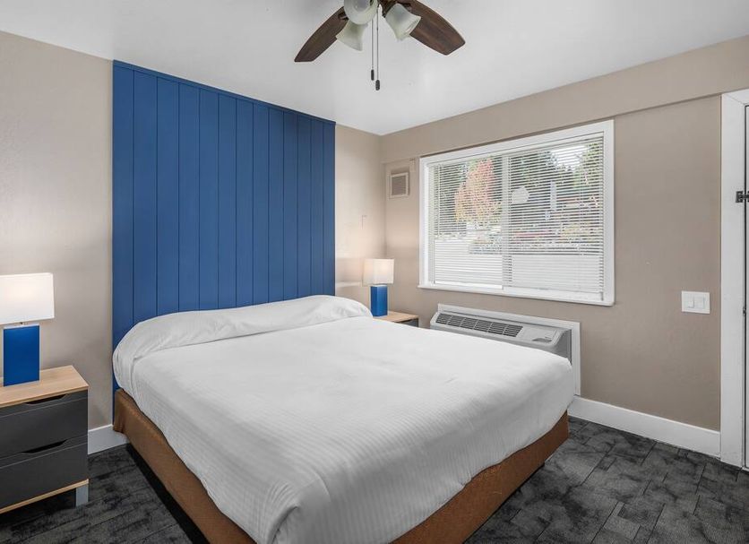 The Inn at Boatworks, Lake Tahoe guest room with king bed, blue accent wall, and window in Tahoe City