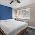 The Inn at Boatworks, Lake Tahoe guest room with king bed, blue accent wall, and window in Tahoe City