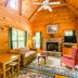 Highland Hills Motel & Cabins in Boone: rustic log cabin living room with stone fireplace and wood walls
