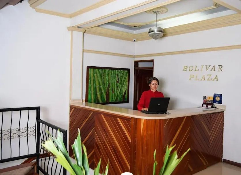 Hotel Bolivar Plaza in Manizales reception desk with staff member and wall-mounted TV