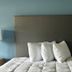 Lakewood Inn & Suites in Dowagiac guest room with bed, white pillows, lamps and blue walls