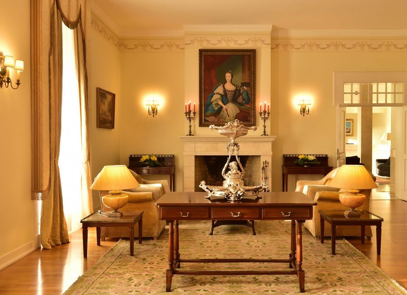 Pousada Palácio de Queluz salon with fireplace, chandelier, antique table and cream seating in Queluz