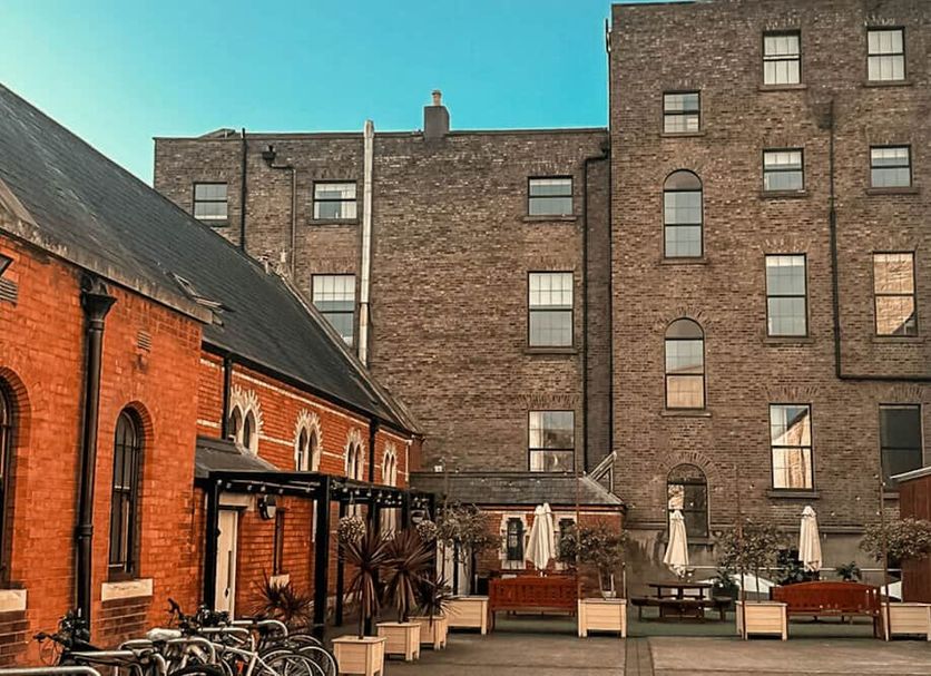 Gardiner House Hostel in Dublin courtyard with outdoor seating beside brick buildings