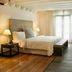 Movich Casa del Alferez in Cali: spacious hotel room with king bed, wood floors, large window, and seating area