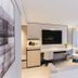 The Bauhinia Hotel - Central, Hong Kong room with wall-mounted TV, desk, chair and sofa