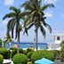 Villablanca Garden Beach Hotel in Cozumel with palm trees, garden, pool umbrellas and ocean view