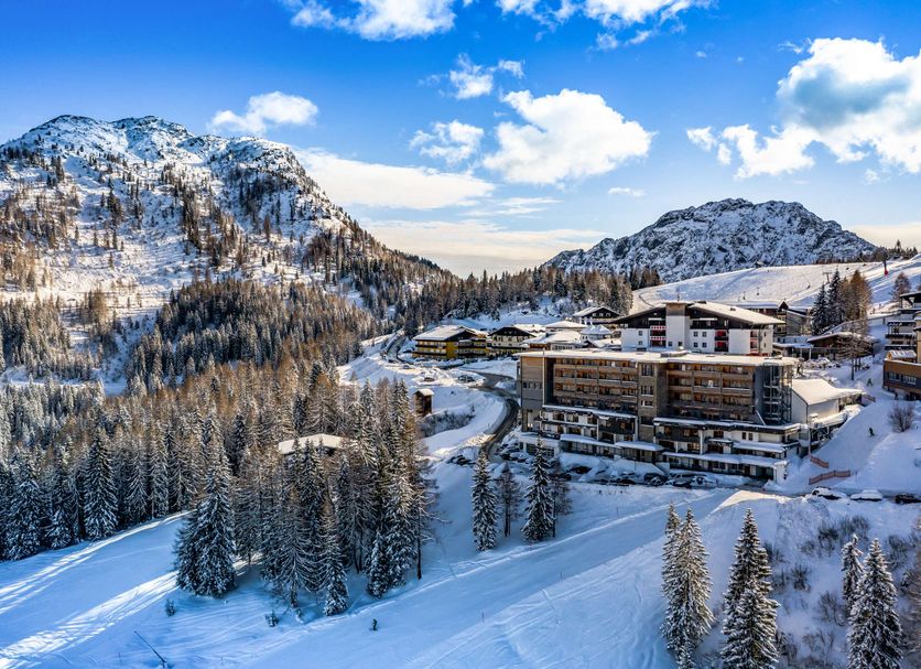 Falkensteiner Family Hotel Sonnenalpe in Hermagor with snowy mountain slopes and forested alpine views