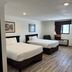 Home Suites in Thief River Falls guest room with two beds, window, and wood-look flooring