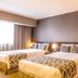Tauá Hotel & Convention Atibaia in Atibaia guest room with two beds, armchair and floor lamp