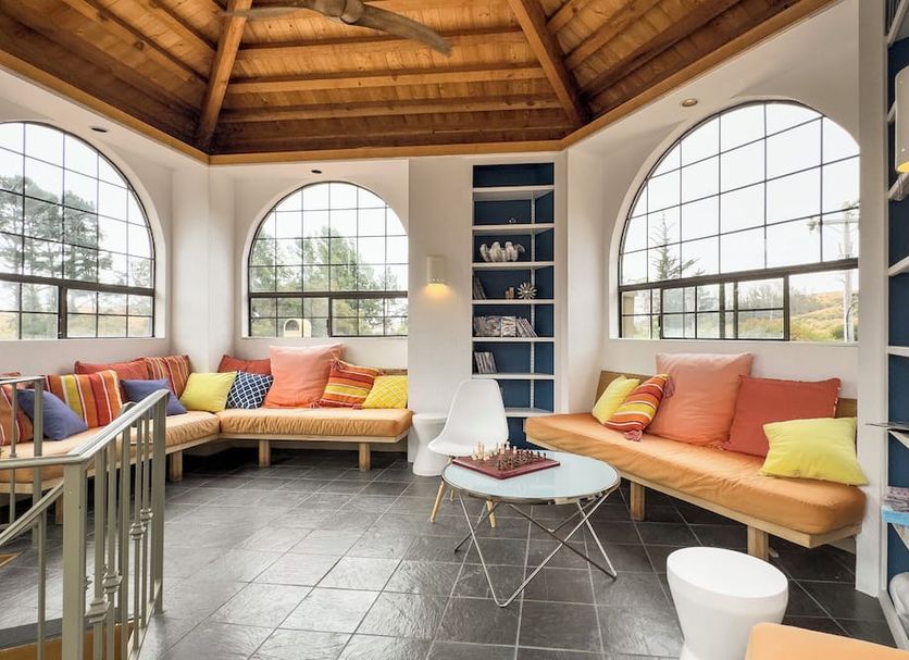 Sonoma Coast Villa in Bodega sunroom with arched windows, daybeds and a round table