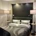Country-Suites By Verdino Living in Braunlage bedroom with bed, bedside lamps and modern wall panel